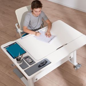 Kind sitzt an Schreibtisch JARO und lernt.