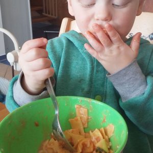 Leonies Kind isst Nudeln mit Tomatensoße