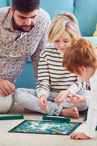 Vater, Tochter und Sohn spielen Scrabble