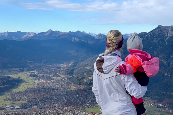 Miriam Neureuther und ihr Kind genießen die Aussicht auf die Berge.