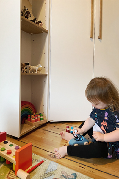 Kind spielt in Paidi Kinderzimmer mit Holzspielzeug.