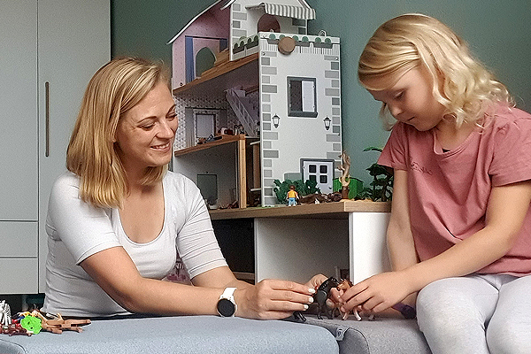 Julia spielt mit ihrer Tochter auf FRITZI Sitzpolstern mit Spielfiguren.