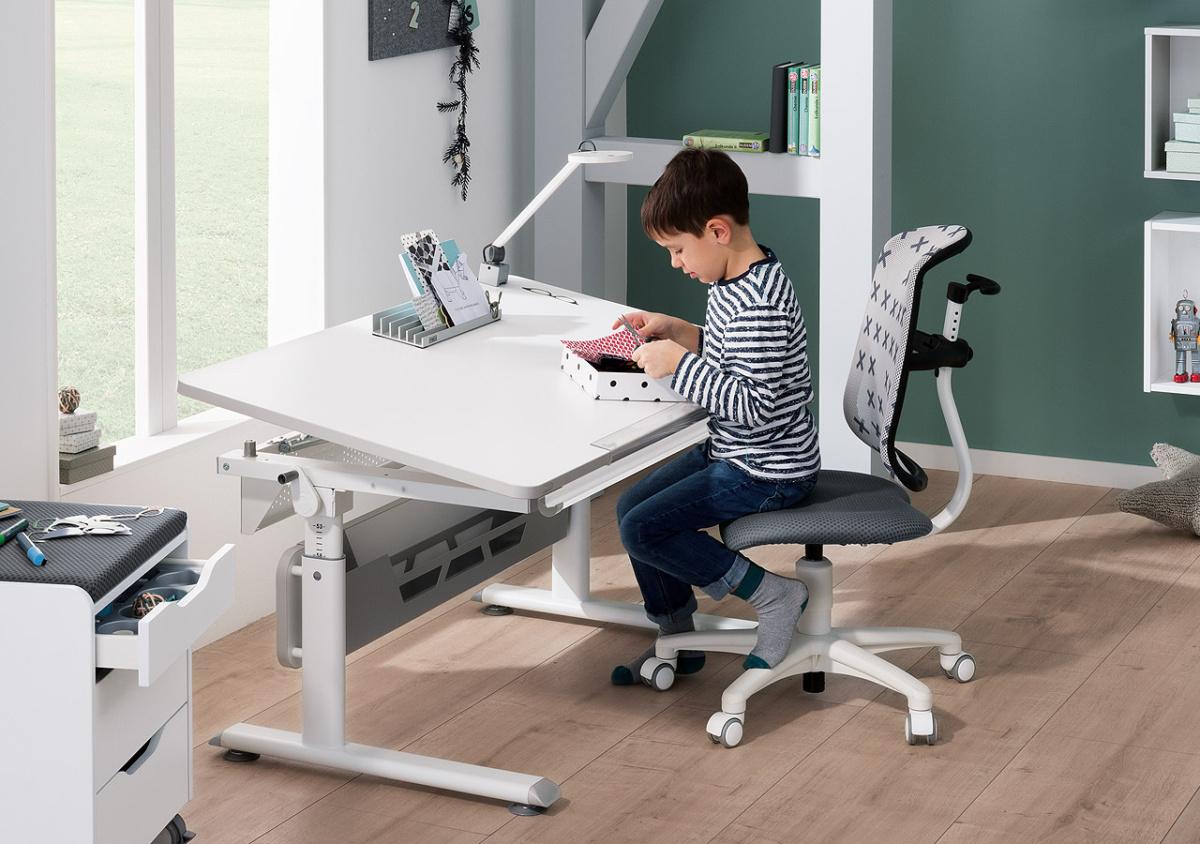 Junge sitzt am PAIDI Schreibtisch Diego