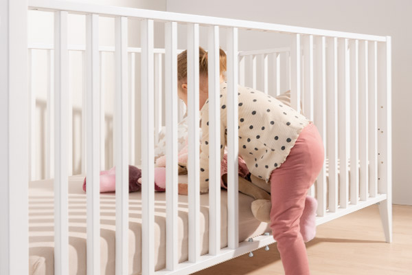 Ein Baby steigt durch die offenen Schluptsprossen in das PAIDI Kettchen ein