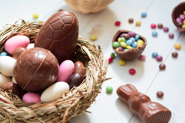 Zu Ostern ein Osternest mit Eiern und Hasen aus Schokolade