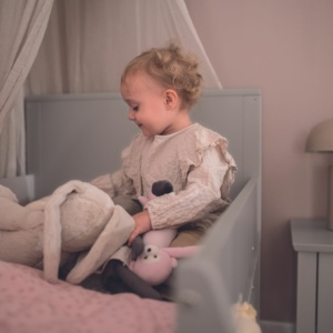 Kind sitzt im PAIDI Kinderbett