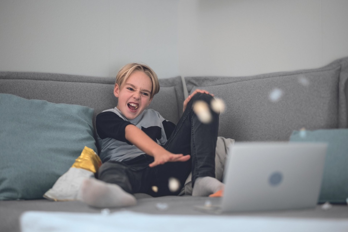 Junge schmeißt Chips durch das Kinderzimmer.