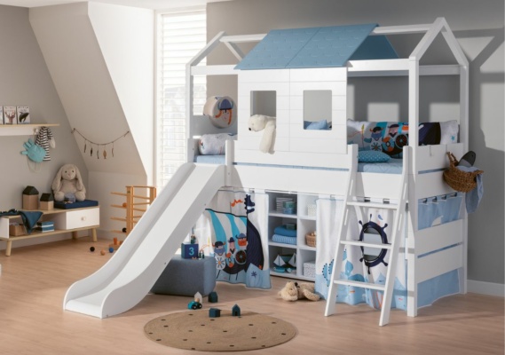 PAIDI Tiny House in der Ausführung als Spielbett mit Rutsche, Vorhang und Dachschindeln. 