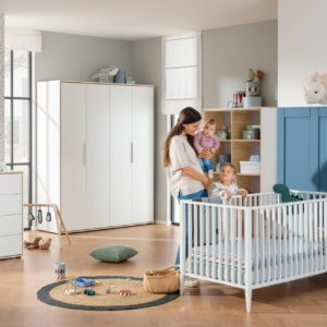 Mutter mit Kind steht im Lieven Babyzimmer